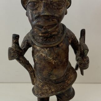 Benin style bronze soldier figure associated with Nigeria wearing a helmet and holding two weapons
